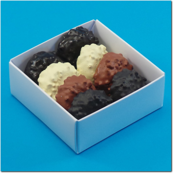 Einwandige weisse Pralinenschachtel mit Inhalt.