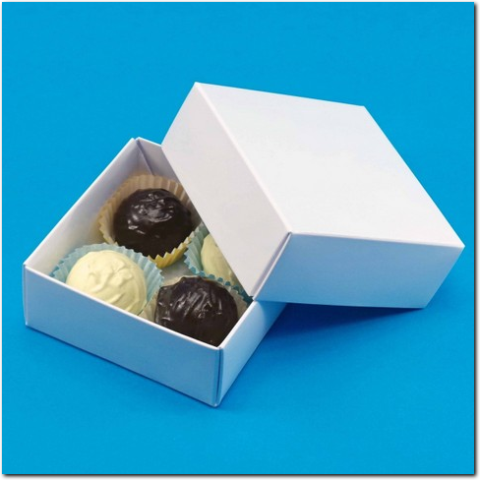 Weisse Geschenkverpackung mit vier Pralinen in Tüten.